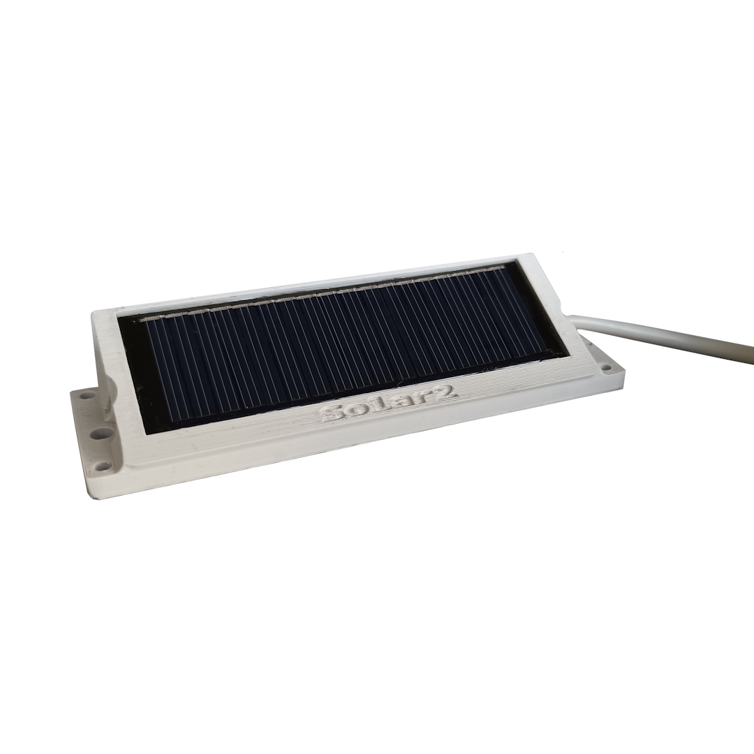 Rechteckige externe Solarzelle in hellem Kunststoffgehäuse. Dunkelblaue bis schwarze Solarfläche mit feinen Gitterlinien oben mittig. Schriftzug "Solar 2". Rechts graues Kabel, links zwei Befestigungslöcher.