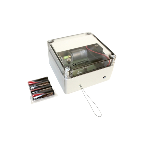 Kleines beigefarbenes elektronisches Gerät mit durchsichtigem Deckel, der Motor und Platine innen zeigt. Ein dünner Drahtbügel ragt seitlich aus dem Gehäuse. Daneben eine Packung mit vier schwarzen AA-Batterien.