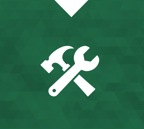 Ein weißes Piktogramm zeigt einen Hammer und einen Schraubenschlüssel, diagonal gekreuzt. Der Hammer ist oben links, der Schraubenschlüssel weist von unten rechts nach oben links. Hintergrund: dunkles, gemustertes Grün mit Dreiecken.