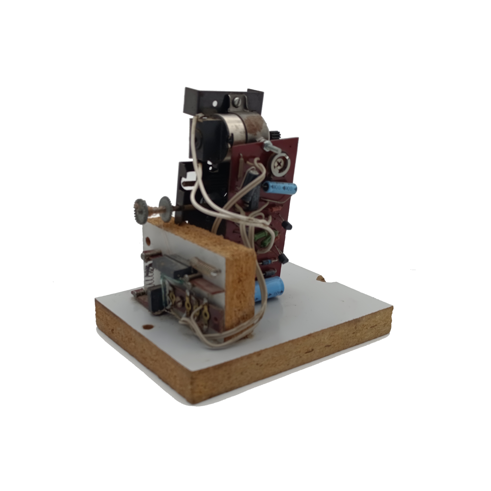 Komplexe elektronische Schaltung auf hellbrauner Holzbasis: senkrechte dunkelrote Platine mit blauen Kondensatoren und weißen Kabeln, oben kleiner Elektromotor sowie seitlich Baugruppe mit Zahnrad. Wirkt wie Vintage-Prototyp.